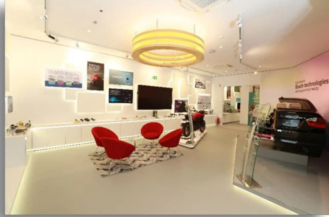 Bosch India Experience Centre: A gallery with red lounge chairs, a classic car and product displays