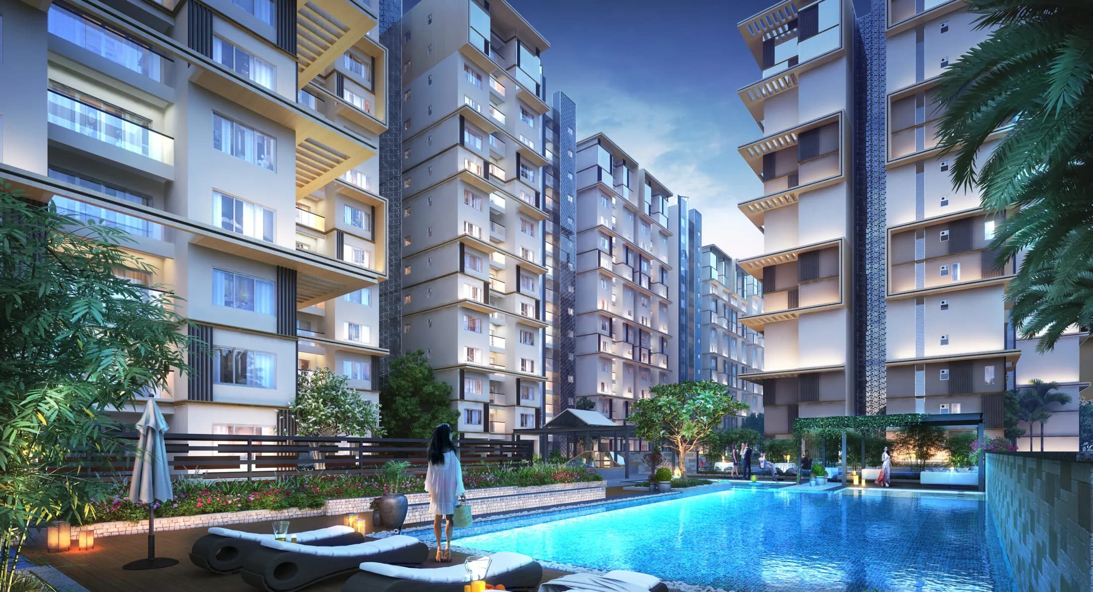 Mahaveer Celesse at dusk — the pool deck with the towers lit behind it