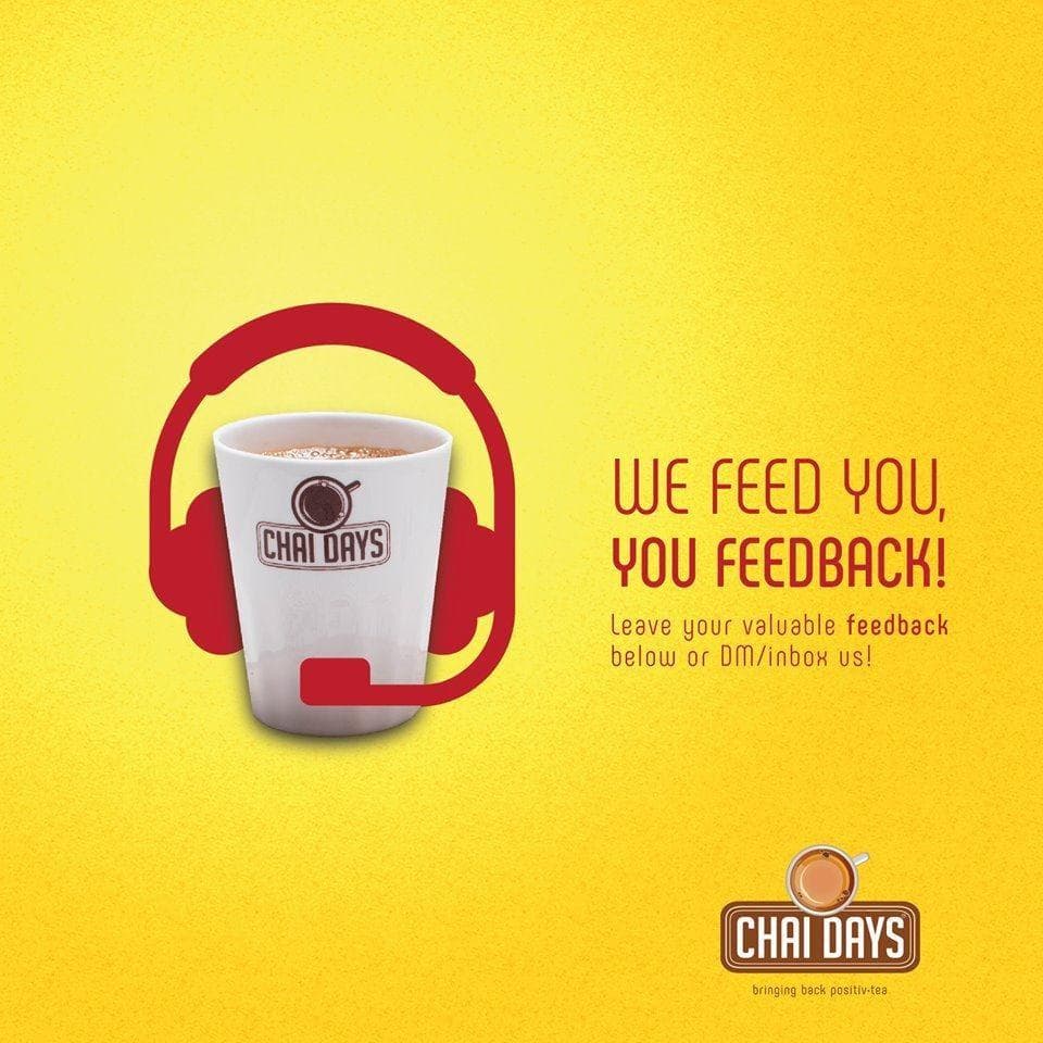 Yellow creative of a Chai Days cup wearing a red customer-service headset, with the text “We feed you, you feedback! Leave your valuable feedback below or DM/inbox us!”