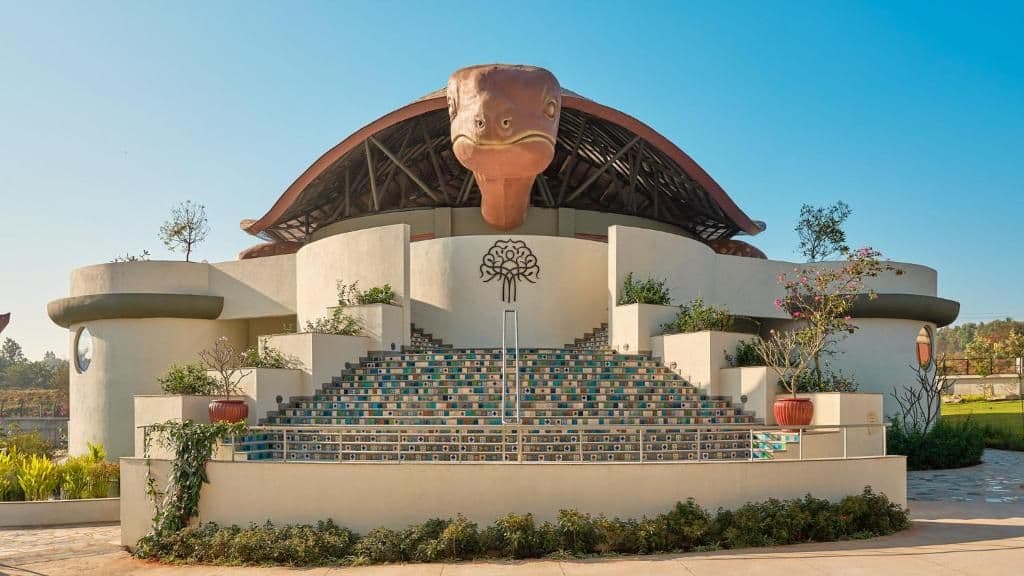 Kshemavana wellness retreat clubhouse with sculpted turtle roof and tiled steps