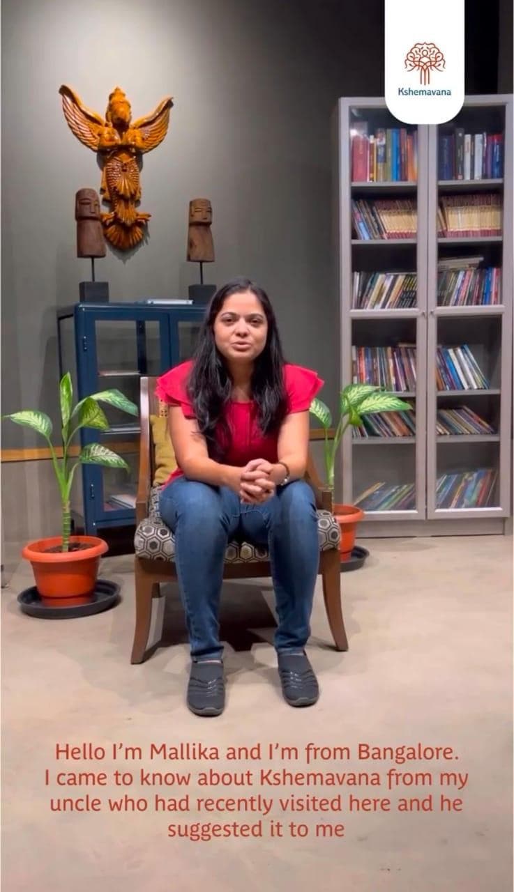 Testimonial video still: Mallika, from Bangalore, seated in a library-style room